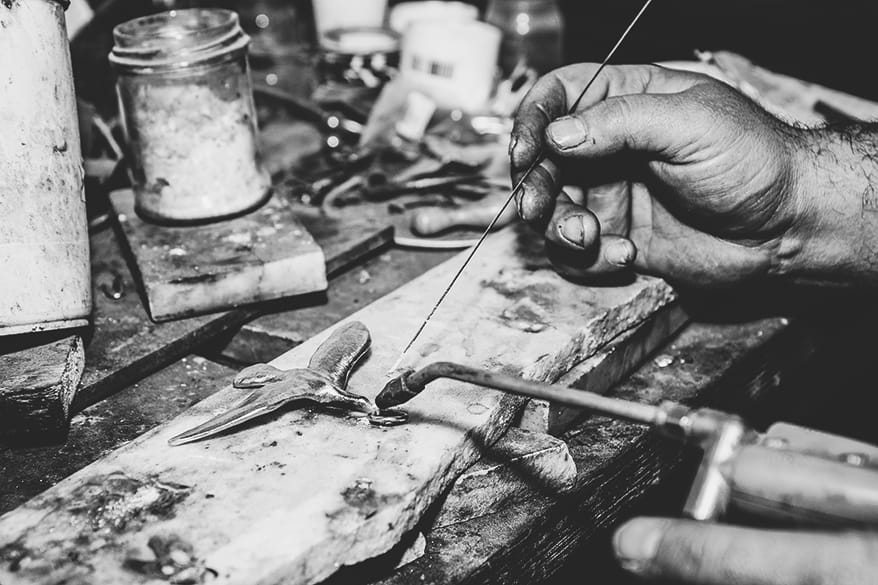 Artigiano al lavoro su un manufatto metallico